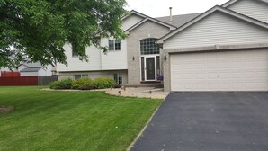 A two-story house with a garage, a well-maintained lawn, and a brick facade. - Location: By Target Center, US Bank Stadium, Target Field & Blaine Sports Ctr! (Blaine)
