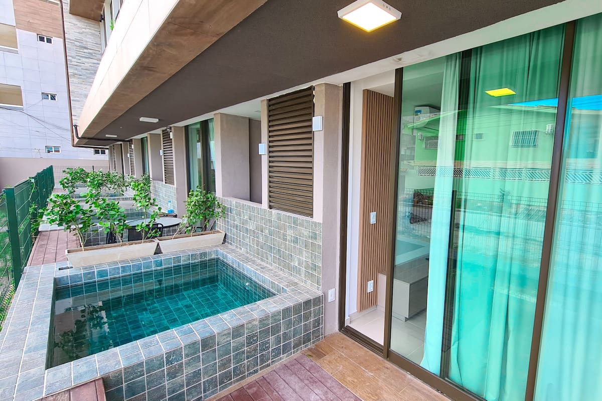 A modern outdoor pool area with tiled flooring, a small pool, and potted plants.