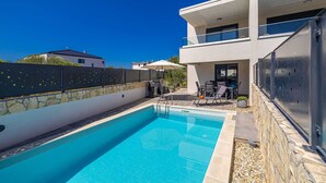 A modern two-story house with a swimming pool, outdoor seating, and a stone wall. - Villa LARUS with private pool (Malinska)