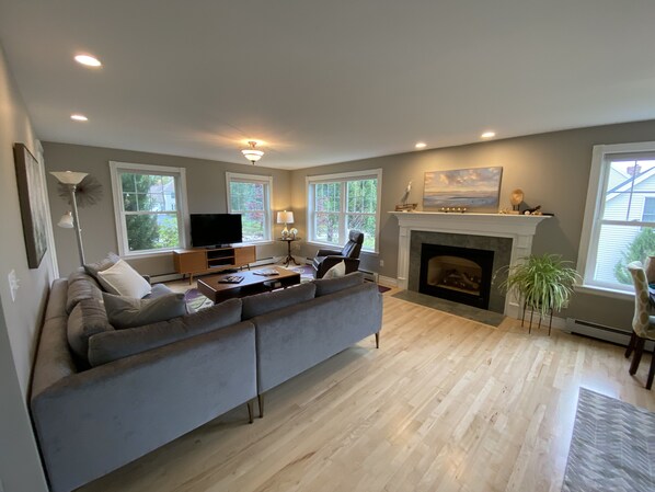 Relax in this inviting living space with a large L-shaped sofa, flat-screen TV, and cozy fireplace.