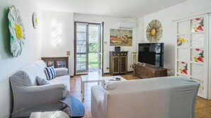 Una sala de estar con sofá, televisor y objetos decorativos.