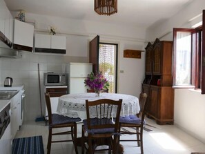 Een koelkast, een oven, kookgerei, borden en bestek