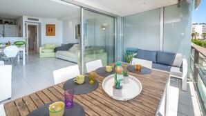 Un espacio habitable moderno con comedor, sofá y balcón con vistas.
