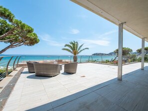 An outdoor terrace with seating and a view of the sea.