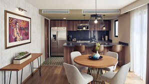 Una cocina moderna con una isla central, electrodomésticos de acero inoxidable e iluminación colgante.
