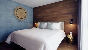 Ein modernes Schlafzimmer mit einem großen Bett, einem Holzkopfende und einem einzigartigen Wandkunstwerk.