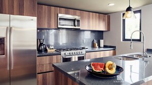 Eine moderne Küche mit Edelstahlgeräten, Holzschränken und einer Arbeitsplatte aus Granit.