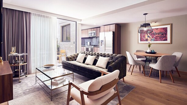 Ein modernes Wohnzimmer mit einer Couch, einem Couchtisch und einem Essbereich mit Stühlen.