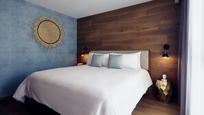 Ein modernes Schlafzimmer mit einem großen Bett, einem Holzkopfende und einer blauen Akzentwand.