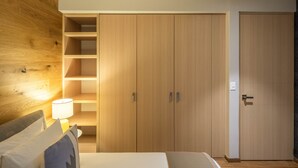 A bedroom with a bed, a nightstand with a lamp, wooden wardrobe with shelves, and a door. - ▶Cool Apt in Condesa 3BD, 3BA (Ciudad de México)