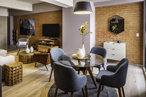 Relax in a stylish living room with a brick accent wall, flat-screen TV, and comfortable seating area.