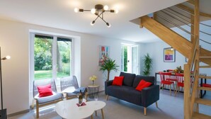 Ein geräumiges Wohnzimmer mit einer Couch, einem Couchtisch und einem Essbereich mit Tisch und Stühlen.