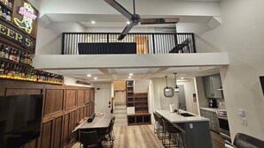 Una cocina moderna con barra, armarios de madera y una mesa de comedor con sillas.