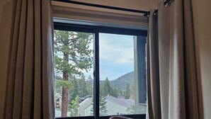 A room with a large window, curtains, and a chair. - Mammoth Lakes Condo-Newly remodeled-Sleeps up to 8 (Mammoth Lakes)