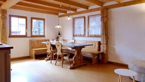 A wooden interior with a dining table, chairs, benches, and a small white table. - Tschingeli by Interhome (Gampel-Bratsch)
