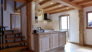 A kitchen with wooden beams, a radio, and a window. - Tschingeli by Interhome (Gampel-Bratsch)