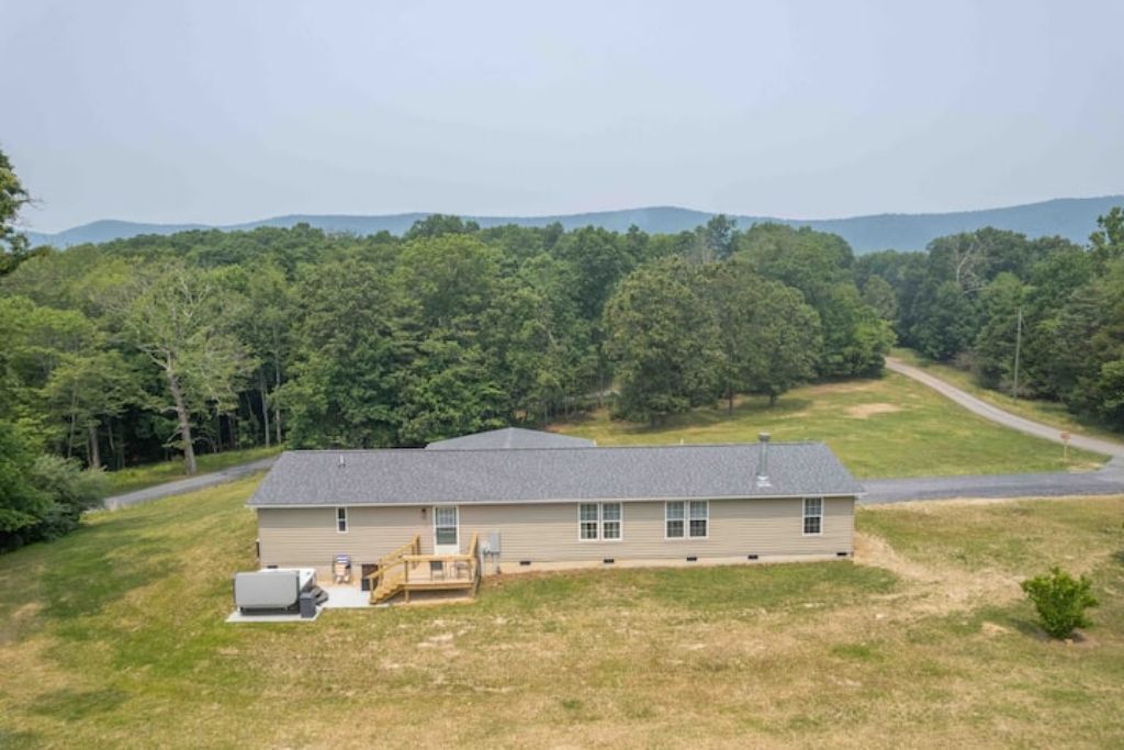 A single-story house with a front porch, a detached garage, and a large yard.