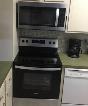 Kitchen equipped with a microwave, stovetop, oven, and dishwasher.