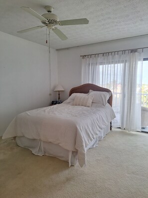Cozy retreat with a single bed, nightstand, and ceiling fan.