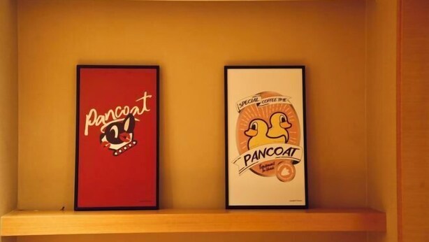 Two framed posters on a shelf.