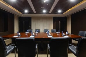 A conference room with a long table, black chairs, and water bottles.