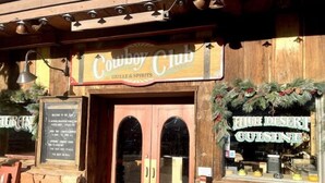 Puinen liike-etuosa, jossa on kyltti, jossa lukee: ”Cowboy Club Grille & Spirits”.