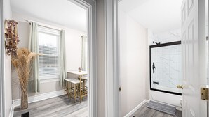 Ein Flur mit Essbereich, einer Badewanne und einer Tür zu einem weiteren Zimmer.