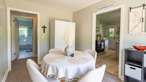 A dining area with a round table, white chairs, and a vase with pampas grass. - Blue Ridge Mountain Getaway (Galax)