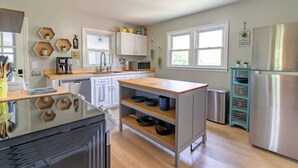 A modern kitchen with white cabinets, a wooden countertop, and a stainless steel refrigerator. - Blue Ridge Mountain Getaway (Galax)