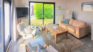 A living room with a sofa, chairs, a coffee table, and a TV. - 2 bedroom nice home in Lemmer (Lemmer)
