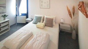A neatly arranged bedroom with a bed, bedside tables, a lamp, and a wall-mounted artwork. - 2 bedroom nice home in Lemmer (Lemmer)