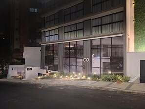 A modern building with large glass windows, a visible entrance, and a sign that reads "GO".