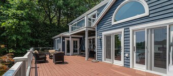 Serene lakefront retreat with an expansive deck, dock access, game room, & AC