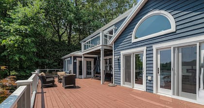 Serene lakefront retreat with an expansive deck, dock access, game room, & AC