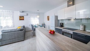 A modern kitchen with white cabinets, a built-in oven, and a wooden countertop. - 2 bedroom beautiful home in Zeliski (Zeliski)