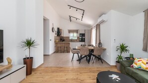 A modern apartment with a dining area, kitchen, and living space. - Pet friendly home in Lopar (Lopar)
