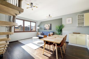 Enjoy a city view from the large window, with a dining table for four and a comfortable seating area.
