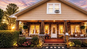 A two-story house with a stone facade, a front porch with a bench, and a mailbox. - Ouachita Spring Studio Stay- Sleeps 4 (Mena)