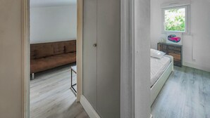 A bedroom with a bed, a window, and a nightstand. - 3 bedroom beach front apartment in Agde (Agde)