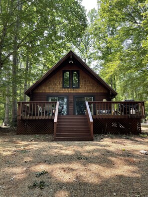 A wooden cabin with a deck and stairs leading to a large window. - Cabin' A Good Time - Lake Front Property (Bumpass)