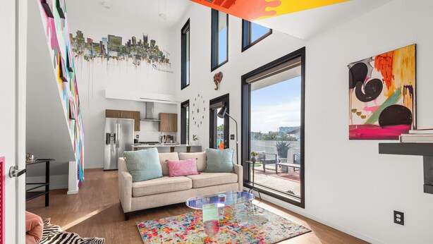 Una sala de estar moderna con un sofá, una mesa de centro y un tapete colorido.