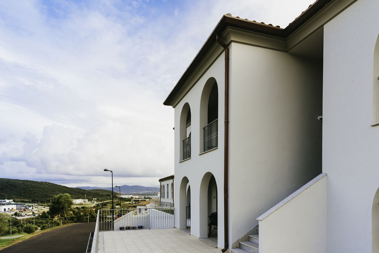 Un edificio blanco con ventanas arqueadas y un balcón.