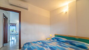 Une chambre à coucher avec un lit, une table de chevet et une lampe fixée au mur.