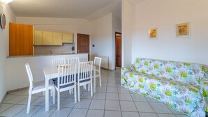 Un espace de vie compact comprenant un coin repas, une kitchenette et un canapé.
