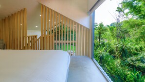 A bedroom with a large bed, a wooden slatted partition, a small table, and a view of lush greenery outside. - Casa del Rio, a little oasis 15 minutes from the airport (Alajuela)