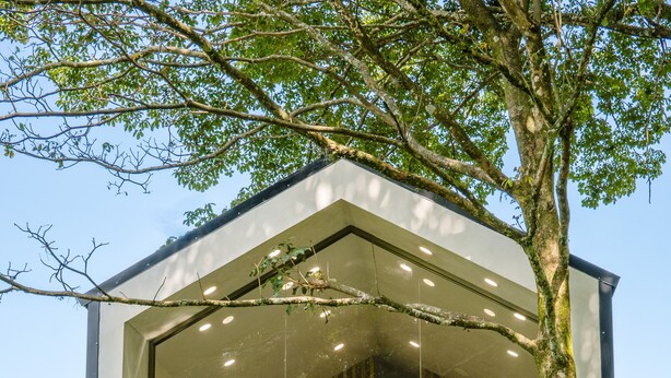 A modern house with a glass facade, outdoor seating area, and a staircase leading to an upper level. - Casa del Rio, a little oasis 15 minutes from the airport (Alajuela)
