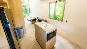 A compact kitchen with a microwave, a small trash bin, and a window with a view of greenery. - Casa del Rio, a little oasis 15 minutes from the airport (Alajuela)