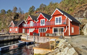A red two-story house with a dock and boats.