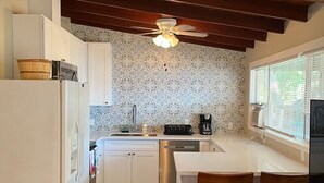 A compact kitchen with a wooden ceiling, a built-in stove, a refrigerator, and a dining area with two chairs. - ALL INCLUSIVE AMENITIES:Kayak,SUP,Pedal Boat,PingPong,Pickleball,Movie Nt &MORE! (Nice)