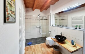 A modern bathroom with a shower, toilet, and sink.